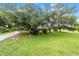 Expansive front yard featuring mature trees offering lots of shade with a long driveway leading to the home at 8940 Sw 8Th St, Ocala, FL 34481