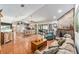 Open-concept living room with terra cotta floors, exposed brick fireplace, and sliding glass doors to the lanai at 8940 Sw 8Th St, Ocala, FL 34481