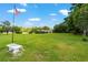 Scenic shot of a home in a lush green landscape with a pond, an American flag, and a classic bench at 8940 Sw 8Th St, Ocala, FL 34481