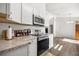 Kitchen featuring stainless steel appliances, white cabinets, and a flat top range at 9 Juniper Pass Trl, Ocala, FL 34480