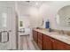 Bright bathroom with a granite double vanity, wood-look floor, and an open doorway to the bedroom at 9309 Sw 106Th Ave, Ocala, FL 34481