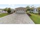 Long paved driveway leading to a detached two-car garage surrounded by manicured lawns and lush landscaping at 9309 Sw 106Th Ave, Ocala, FL 34481