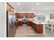 Bright kitchen features wood cabinets, stainless appliances, stone countertops, and wood floors at 9309 Sw 106Th Ave, Ocala, FL 34481