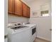 Bright laundry room with wooden cabinets and modern, front-loading washer and dryer at 9309 Sw 106Th Ave, Ocala, FL 34481