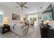 Comfortable living room with neutral furniture, ceiling fan, and sliding glass doors to lanai at 9309 Sw 106Th Ave, Ocala, FL 34481