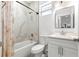 Clean bathroom featuring a modern vanity, toilet, and a shower with marbled walls and a shower curtain at 10291 Se 67Th Ter, Belleview, FL 34420