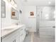 Bathroom featuring double sink vanity, modern mirrors, walk-in shower, and marble-look tile at 10291 Se 67Th Ter, Belleview, FL 34420