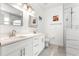 Bathroom featuring double sink vanity, modern mirrors, walk-in shower, and marble-look tile at 10291 Se 67Th Ter, Belleview, FL 34420