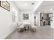 Modern dining area featuring a built-in bench, a white table, and gray tile floors at 10291 Se 67Th Ter, Belleview, FL 34420
