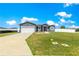 Inviting single-story home featuring a two-car garage, well-maintained lawn, and a red front door at 10291 Se 67Th Ter, Belleview, FL 34420