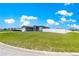 Spacious front lawn with a gray one-story home and white fence at 10291 Se 67Th Ter, Belleview, FL 34420
