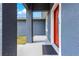 Modern front porch with sleek gray walls and a vibrant red door at 10291 Se 67Th Ter, Belleview, FL 34420