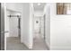 A brightly lit hallway with tile flooring that leads to a bathroom and bedrooms at 10291 Se 67Th Ter, Belleview, FL 34420
