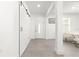 Bright hallway with gray tile floors, white walls, and a sliding barn door at 10291 Se 67Th Ter, Belleview, FL 34420