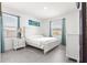 A serene main bedroom with neutral décor, abundant windows, and luxury tile flooring at 10291 Se 67Th Ter, Belleview, FL 34420