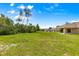 A spacious backyard featuring a covered patio, lush green lawn, and serene landscaping, ideal for outdoor relaxation at 10313 Sw 45Th Ave, Ocala, FL 34476