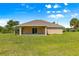Home exterior featuring a covered patio and spacious grassy backyard, perfect for entertaining and relaxing at 10313 Sw 45Th Ave, Ocala, FL 34476