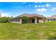 Home exterior with covered patio overlooking spacious yard, perfect for outdoor enjoyment and relaxation at 10313 Sw 45Th Ave, Ocala, FL 34476