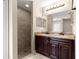Bathroom featuring double vanity, granite countertop, and a walk-in shower at 10313 Sw 45Th Ave, Ocala, FL 34476