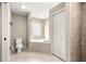 Bright bathroom featuring a tiled tub, tile flooring, and a neutral color scheme at 10313 Sw 45Th Ave, Ocala, FL 34476