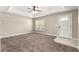 Bedroom featuring neutral paint, carpet flooring, a ceiling fan and an entry door at 10313 Sw 45Th Ave, Ocala, FL 34476