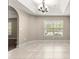 Bright dining room boasts tile flooring, a tray ceiling with chandelier, and a large window at 10313 Sw 45Th Ave, Ocala, FL 34476