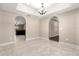 Dining room featuring tile floors, arched entryways, and a tray ceiling with chandelier at 10313 Sw 45Th Ave, Ocala, FL 34476