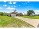 A cozy single-story home with an attached garage and long driveway surrounded by a large green lawn at 10313 Sw 45Th Ave, Ocala, FL 34476