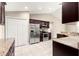 Kitchen area with stainless steel appliances, tiled flooring, and dark wood cabinetry at 10313 Sw 45Th Ave, Ocala, FL 34476