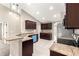 Kitchen area with granite countertops, tiled flooring, stainless steel appliances, and dark wood cabinetry at 10313 Sw 45Th Ave, Ocala, FL 34476