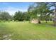 Sprawling backyard view, featuring a shed and bordered by mature trees, ample green space at 10716 Sw 53Rd Cir, Ocala, FL 34476