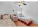 A comfortable bedroom with two beds, hardwood floors, a ceiling fan, and an abundance of natural light at 10716 Sw 53Rd Cir, Ocala, FL 34476