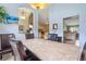 Bright dining room featuring high ceilings, an elegant chandelier, and a marble-topped table with leather chairs at 10716 Sw 53Rd Cir, Ocala, FL 34476