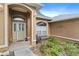 Inviting front porch with a seating area, a beige door with glass inserts, and desert landscaping at 10716 Sw 53Rd Cir, Ocala, FL 34476