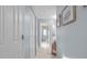 Long hallway with artwork on the wall leading to a bright area in this beautiful home at 10716 Sw 53Rd Cir, Ocala, FL 34476