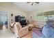 Comfortable living room with tan leather seating, a television, and sliding glass doors to the exterior at 10716 Sw 53Rd Cir, Ocala, FL 34476