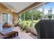 A charming screened-in porch with cozy furniture and a view of a lush backyard providing relaxation at 10716 Sw 53Rd Cir, Ocala, FL 34476