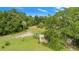 Aerial view of the green backyard with a shed, palm trees, and shady trees at 10716 Sw 53Rd Cir, Ocala, FL 34476
