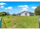 Exterior view of home with a spacious fenced backyard and partial view of the screened-in porch at 11237 Sw 78Th Ct, Ocala, FL 34476