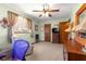 This bedroom features a ceiling fan and plentiful natural light that filters through the curtains at 11237 Sw 78Th Ct, Ocala, FL 34476