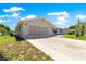 Garage and driveway featuring neutral colors and manicured lawn at 11237 Sw 78Th Ct, Ocala, FL 34476