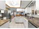 Well-lit kitchen showcasing white cabinets, granite counters, and stainless steel refrigerator at 11237 Sw 78Th Ct, Ocala, FL 34476