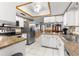Modern kitchen features a stainless steel refrigerator, white cabinets, and granite countertops at 11237 Sw 78Th Ct, Ocala, FL 34476