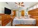 Large bedroom with wooden furniture, a ceiling fan, a TV and an ensuite bathroom at 11237 Sw 78Th Ct, Ocala, FL 34476
