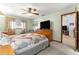 Main bedroom with wood furniture, ceiling fan, ensuite bathroom and large TV at 11237 Sw 78Th Ct, Ocala, FL 34476