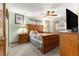 Main bedroom with wood furniture, neutral walls and carpet, ceiling fan and ensuite bathroom at 11237 Sw 78Th Ct, Ocala, FL 34476
