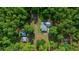 Aerial view of a single-Gathering home and storage buildings surrounded by mature trees offering privacy at 11521 Se 1St Street Rd, Silver Springs, FL 34488
