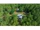 An aerial view showing the home and outbuildings on a lot surrounded by lush greenery and trees at 11521 Se 1St Street Rd, Silver Springs, FL 34488