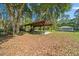 Expansive backyard with covered structure and a storage shed amid lush greenery at 11521 Se 1St Street Rd, Silver Springs, FL 34488