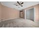 A bedroom with carpeted floor, neutral walls, ceiling fan, and a walk-in closet providing ample storage at 11521 Se 1St Street Rd, Silver Springs, FL 34488